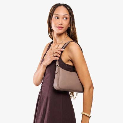 Sparrow*Small | Model carrying petite bean shaped shoulder bag with a zipper closure