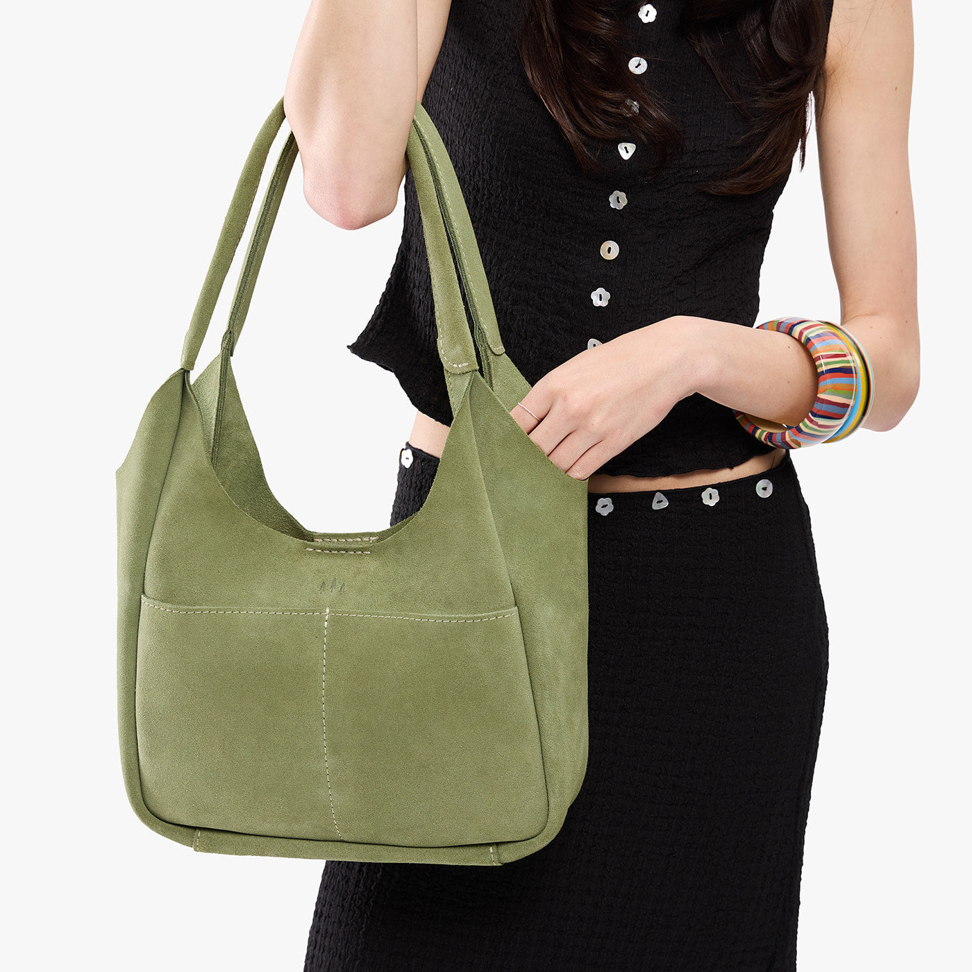 Laurel*Large | A model holding a u-shaped, flat-bottomed leather shoulder bag with two outside pockets