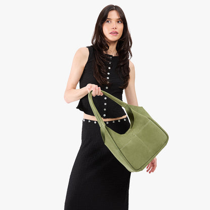 Laurel*Large | A model holding a u-shaped, flat-bottomed leather shoulder bag with two outside pockets