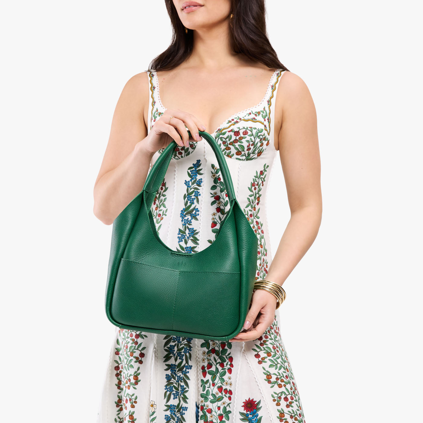 Bacalar*Medium | Model holding U-shaped, flat-bottomed leather shoulder bag with two outside pockets