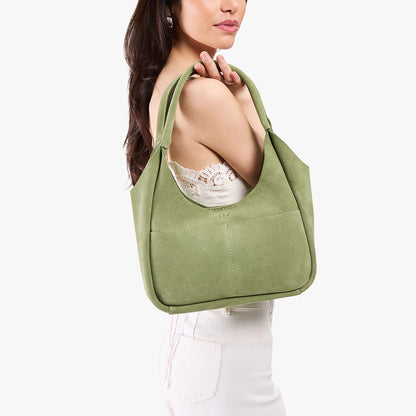 Laurel*Medium | A model holding a u-shaped, flat-bottomed leather shoulder bag with two outside pockets