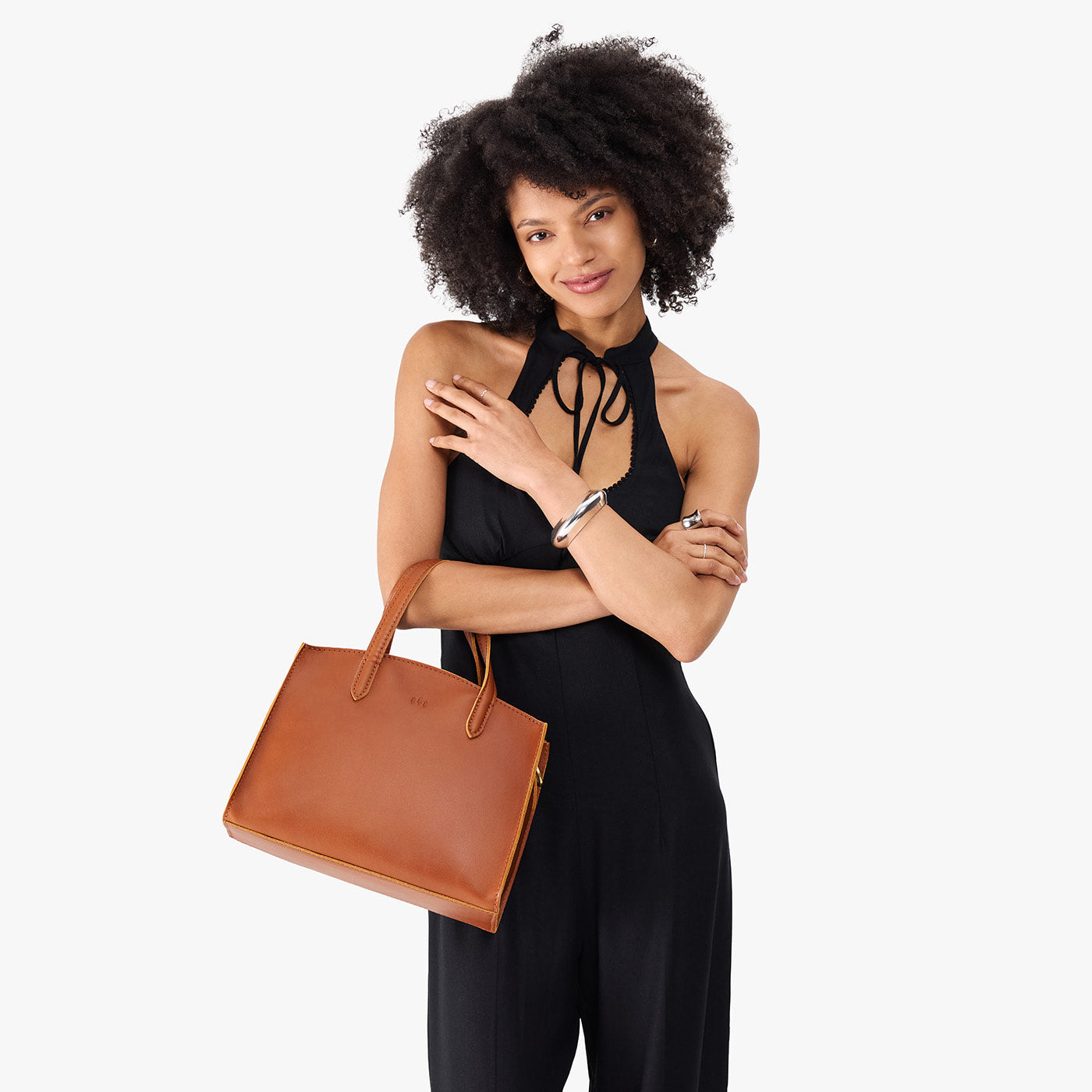 Honey*Medium | Model carrying leather tote bag with handles, adjustable crossbody strap, and two back pockets