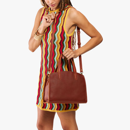 Nutmeg*Medium | Model carrying leather tote bag with handles, adjustable crossbody strap, and two back pockets