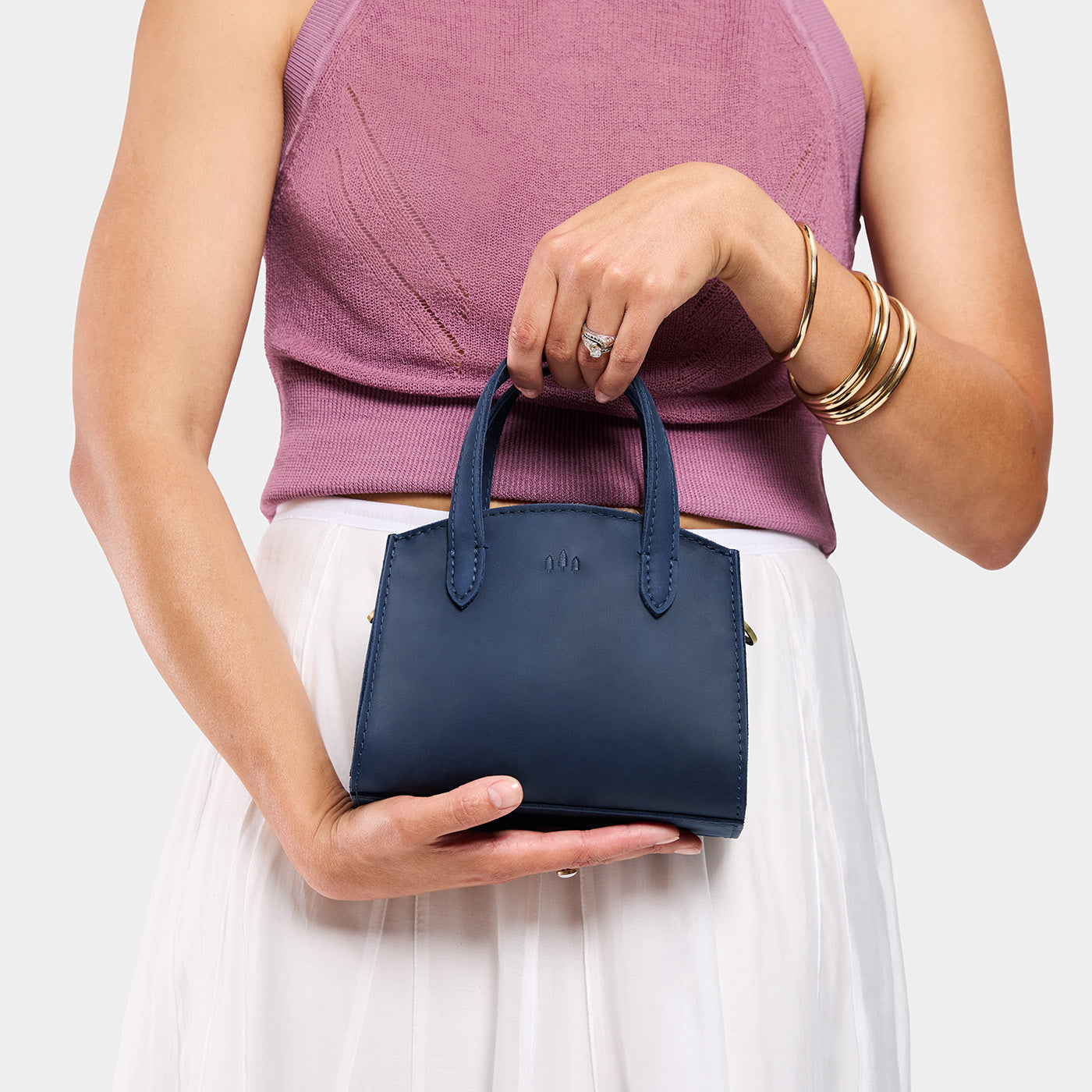 Deep Water*Mini | Model holdng small leather tote bag with handles, adjustable crossbody strap, and one back pocket