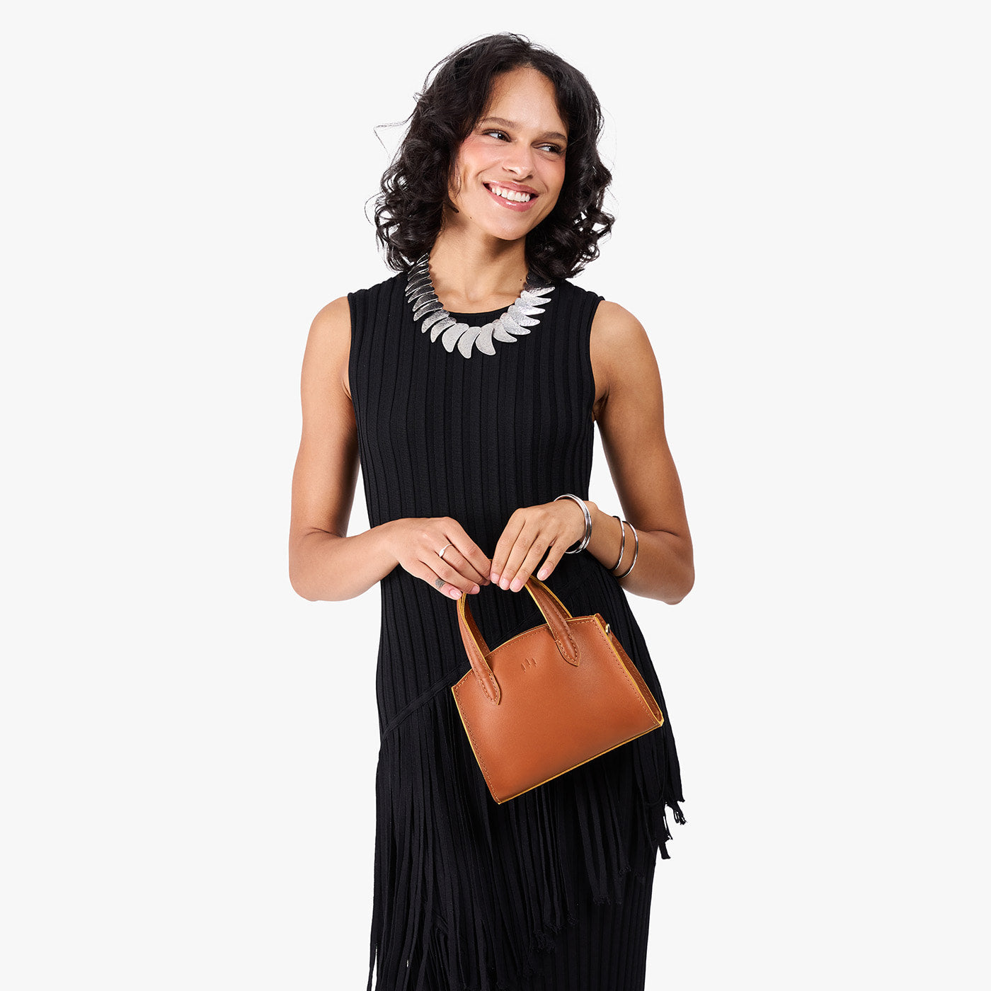 Honey*Mini | Model carrying small leather tote bag with handles, adjustable crossbody strap, and one back pocket