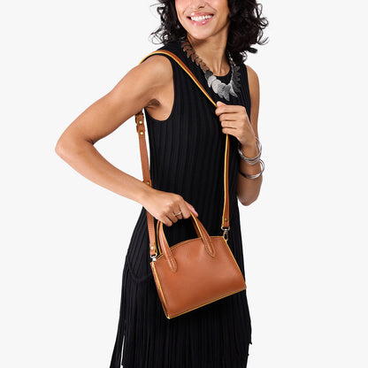 Honey*Mini | Model carrying small leather tote bag with handles, adjustable crossbody strap, and one back pocket