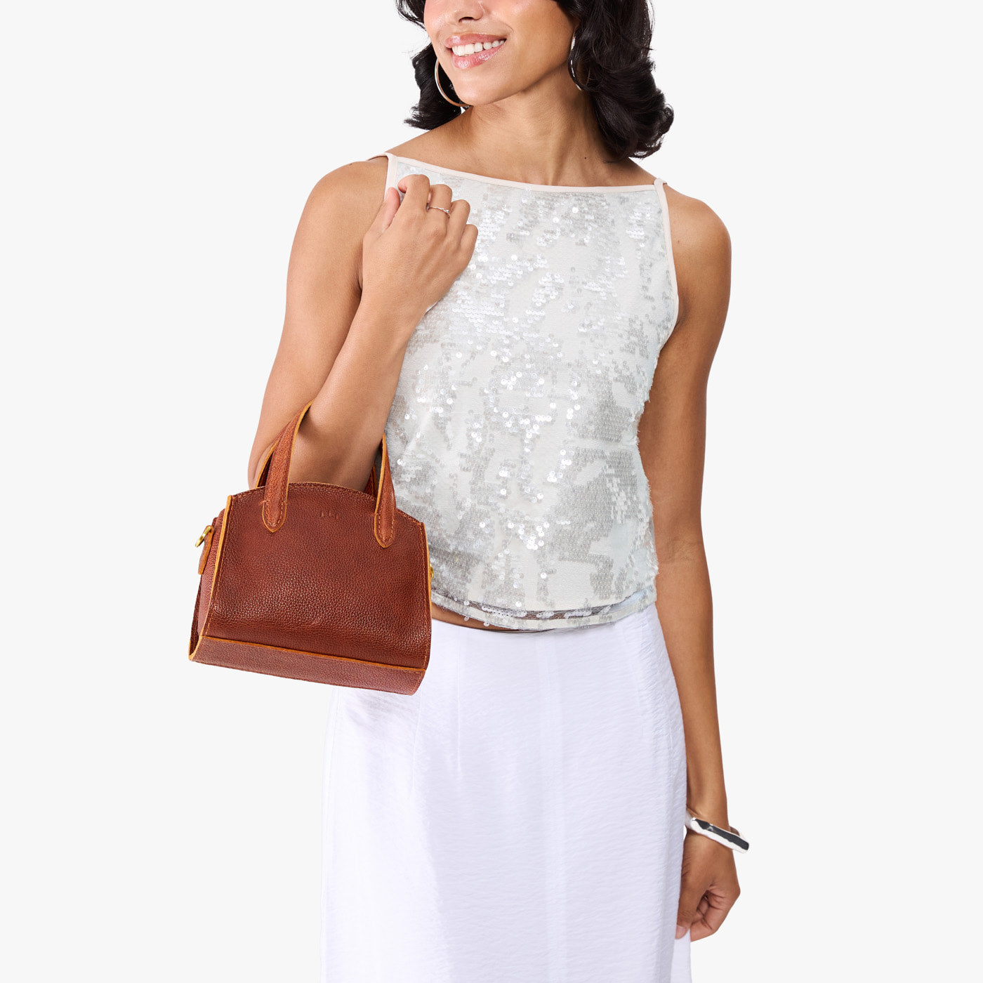 Nutmeg*Mini | Model carrying small leather tote bag with handles, adjustable crossbody strap, and one back pocket