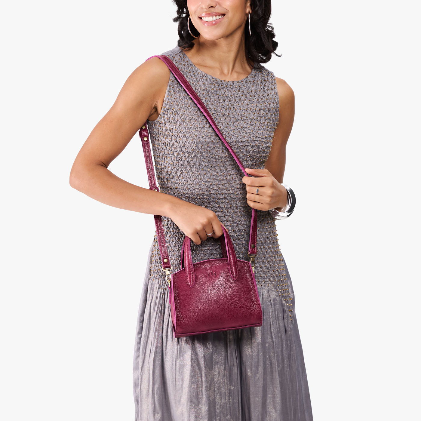 Orchid*Mini | Model carrying small leather tote bag with handles, adjustable crossbody strap, and one back pocket