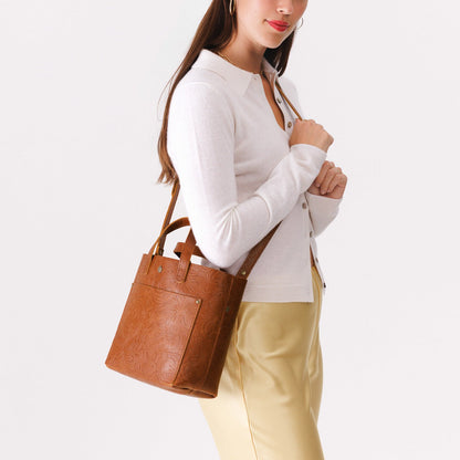 Meadow*Classic | Model holding crossbody tote bag with snap closure and front pocket