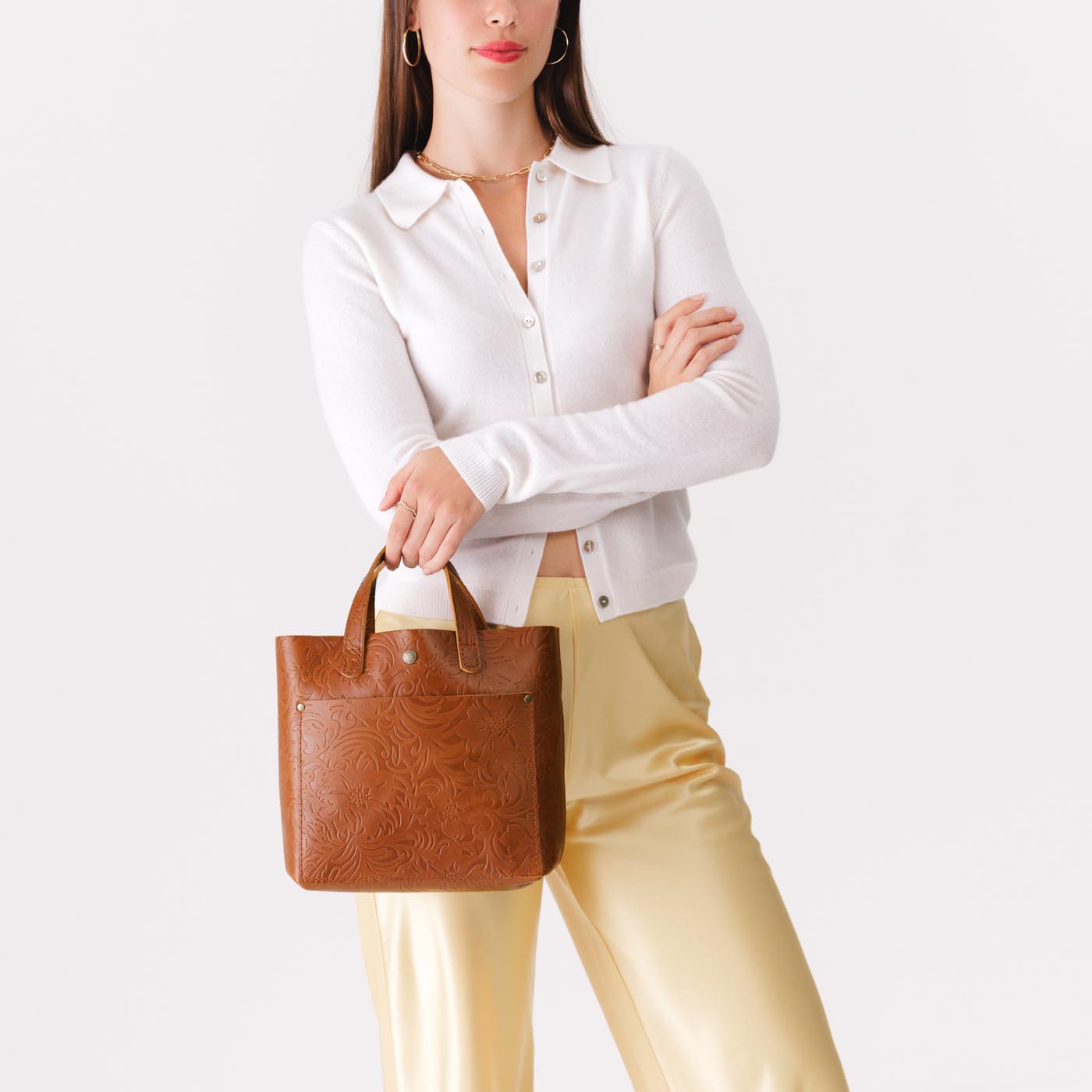 Meadow*Classic | Model holding crossbody tote bag with snap closure and front pocket