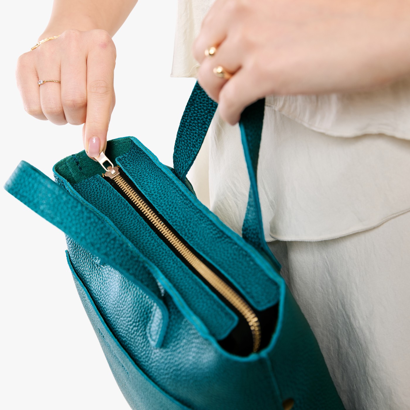 Aquarius*Zipper | Model holding crossbody tote bag with zipper closure and front pocket