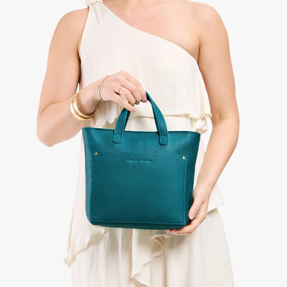 Aquarius*Zipper | Model holding crossbody tote bag with zipper closure and front pocket