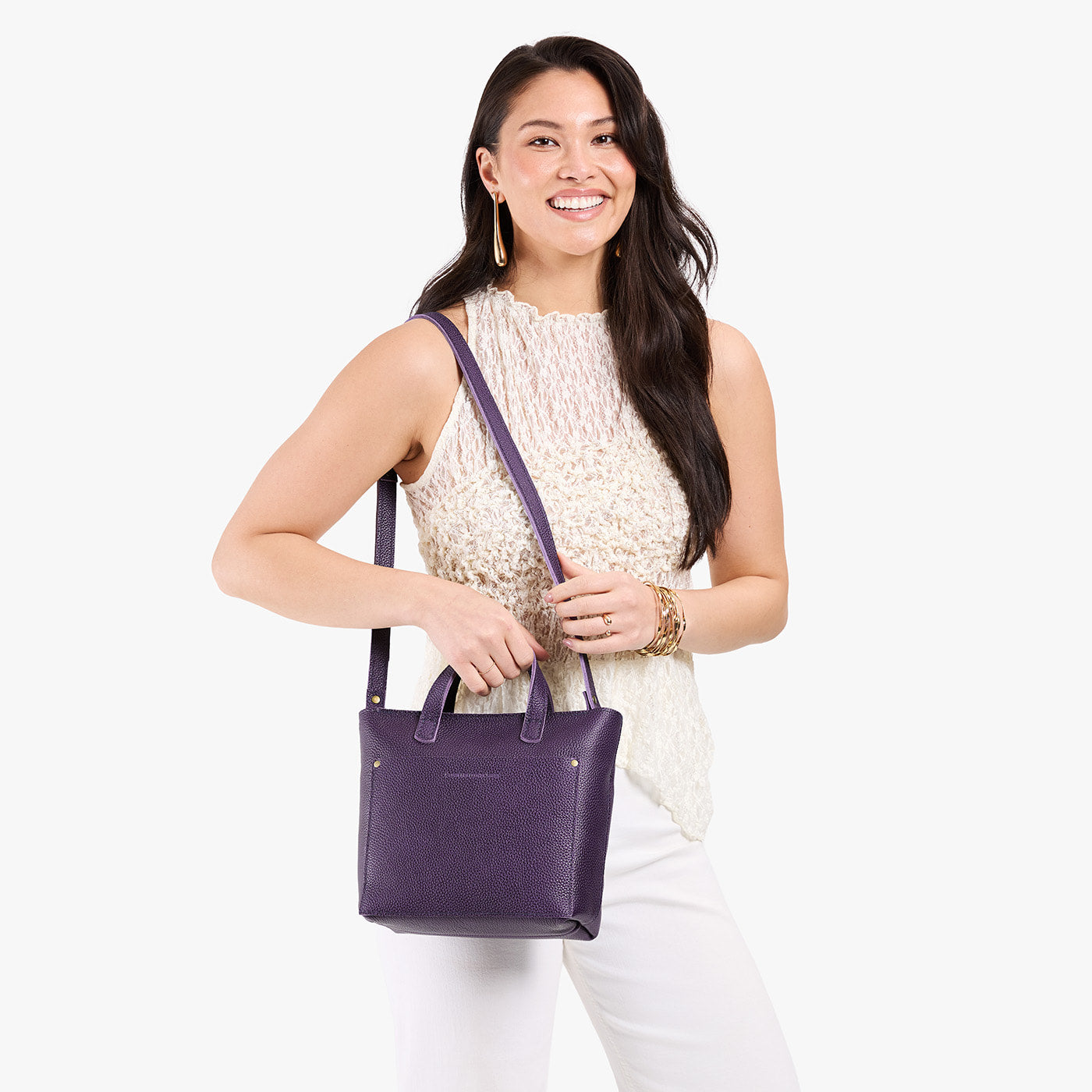 Empire*Zipper | Model holding crossbody tote bag with zipper closure and front pocket