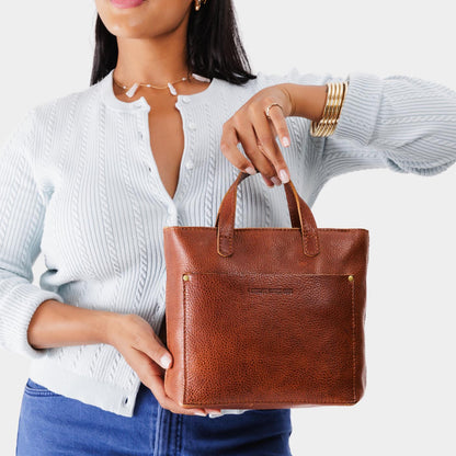 Nutmeg*Zipper | Model holding crossbody tote bag with zipper closure and front pocket