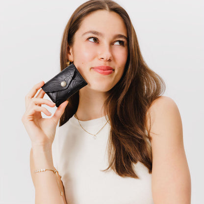 Dahlia | Model holding small leather wallet with scalloped edge