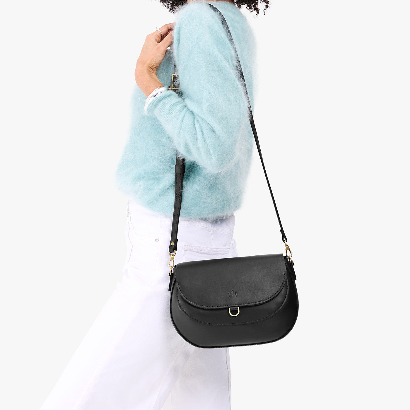 Black*Large | Model wearing a leather Crossbody with a flap and magnetic closure