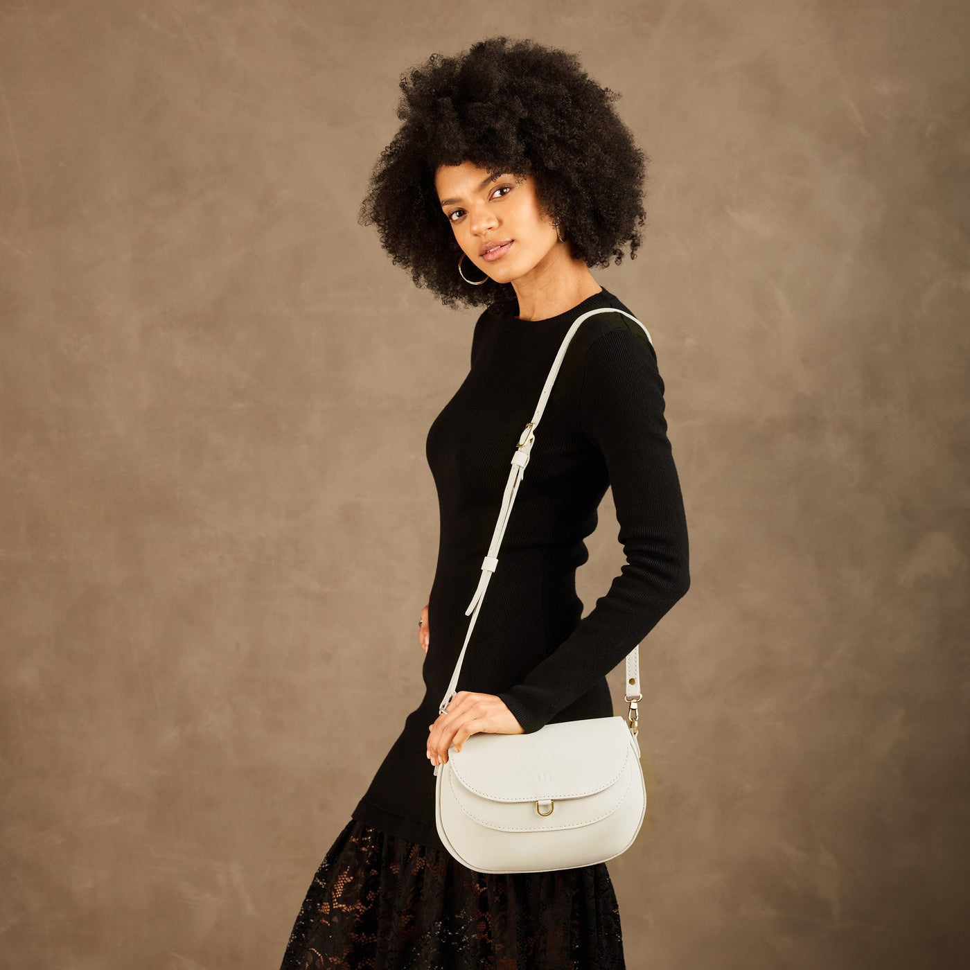 Bone*Large | Model wearing a leather Crossbody with a flap and magnetic closure