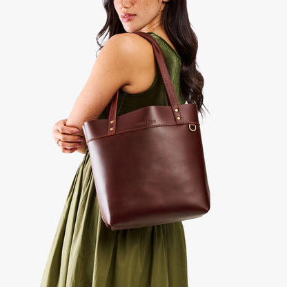 Cognac*Medium*Classic | Model wearing leather tote bag with riveted straps and exterior key loop