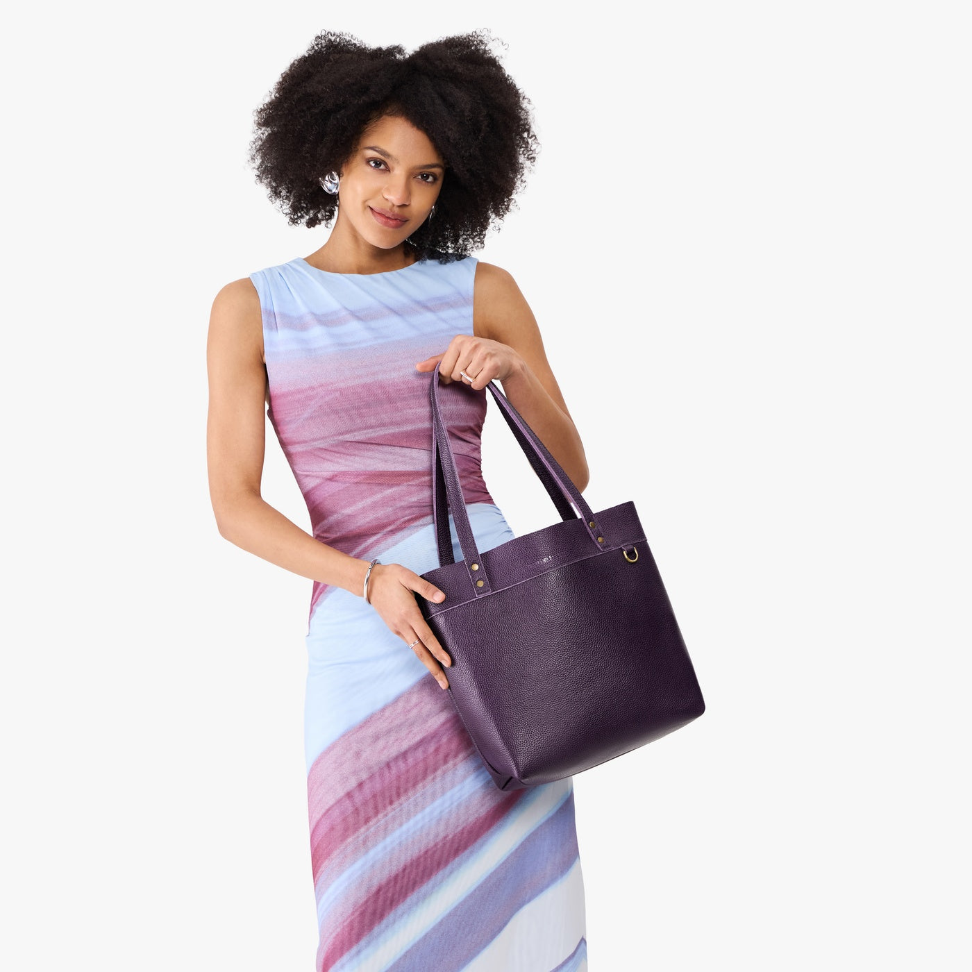 Empire*Medium*Classic | Model holding leather tote bag with riveted straps and exterior key loop
