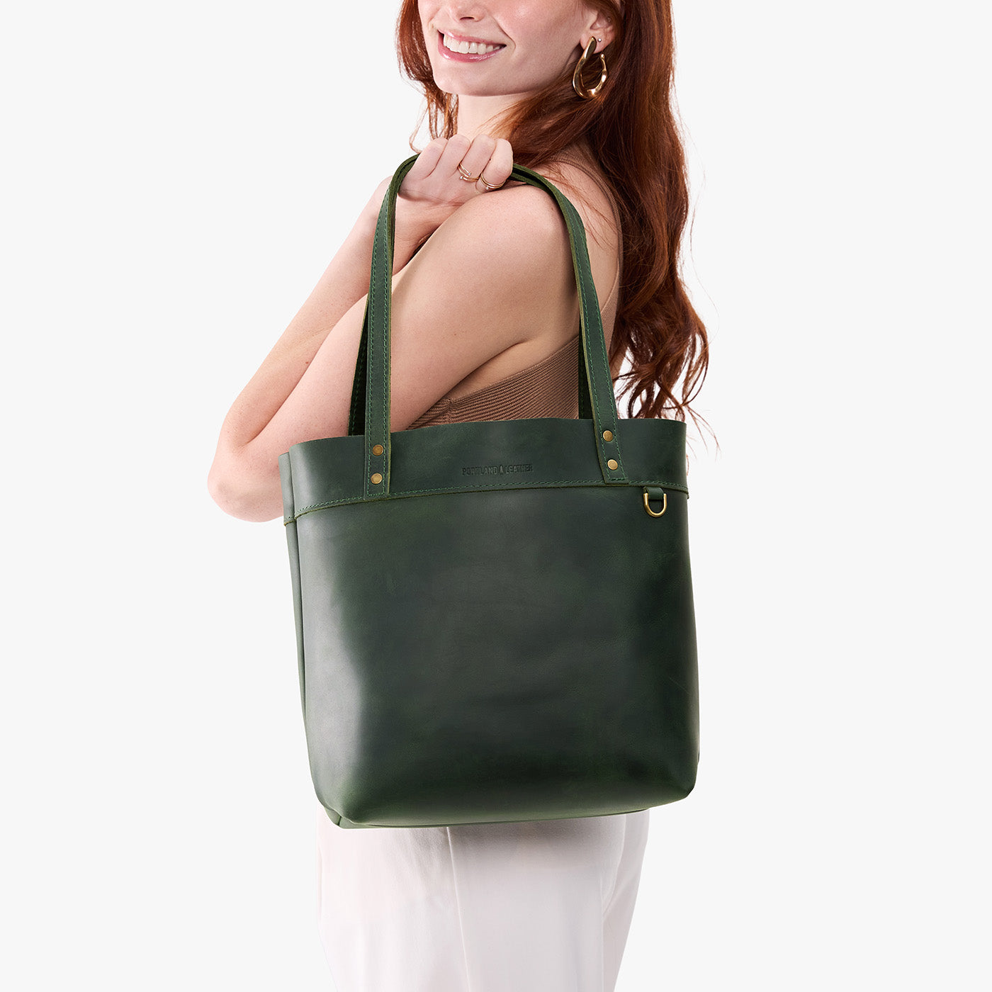 Evergreen*Medium*Classic | Model wearing leather tote bag with riveted straps and exterior key loop