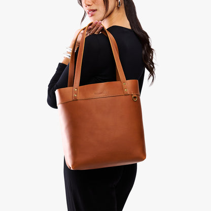 Honey*Medium*Classic | Model wearing leather tote bag with riveted straps and exterior key loop