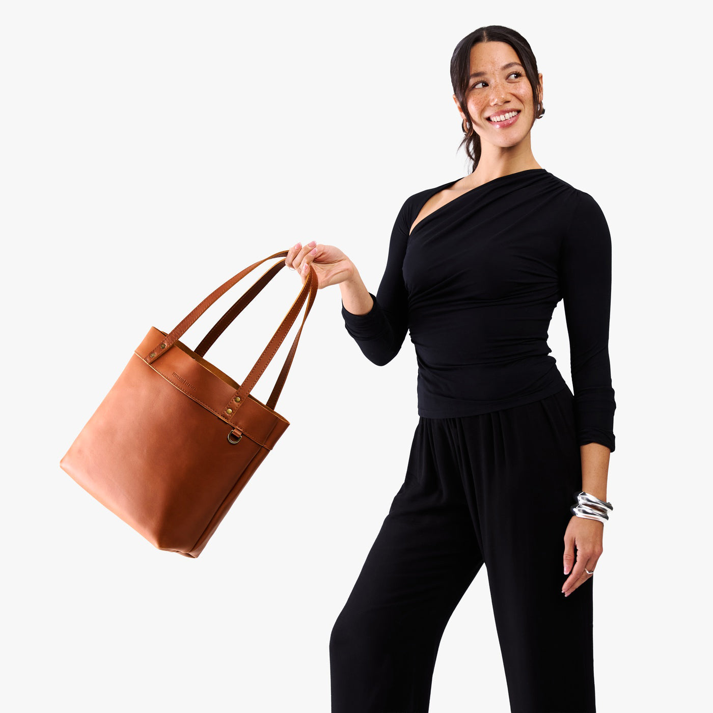 Honey*Medium*Classic | Model wearing leather tote bag with riveted straps and exterior key loop