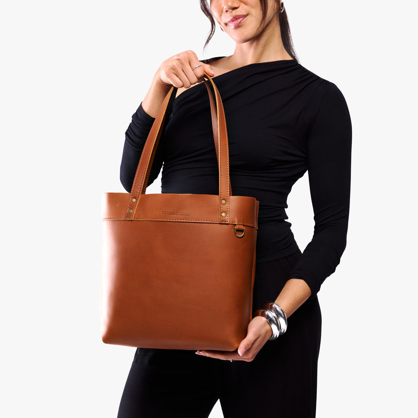 Honey*Medium*Classic | Model wearing leather tote bag with riveted straps and exterior key loop