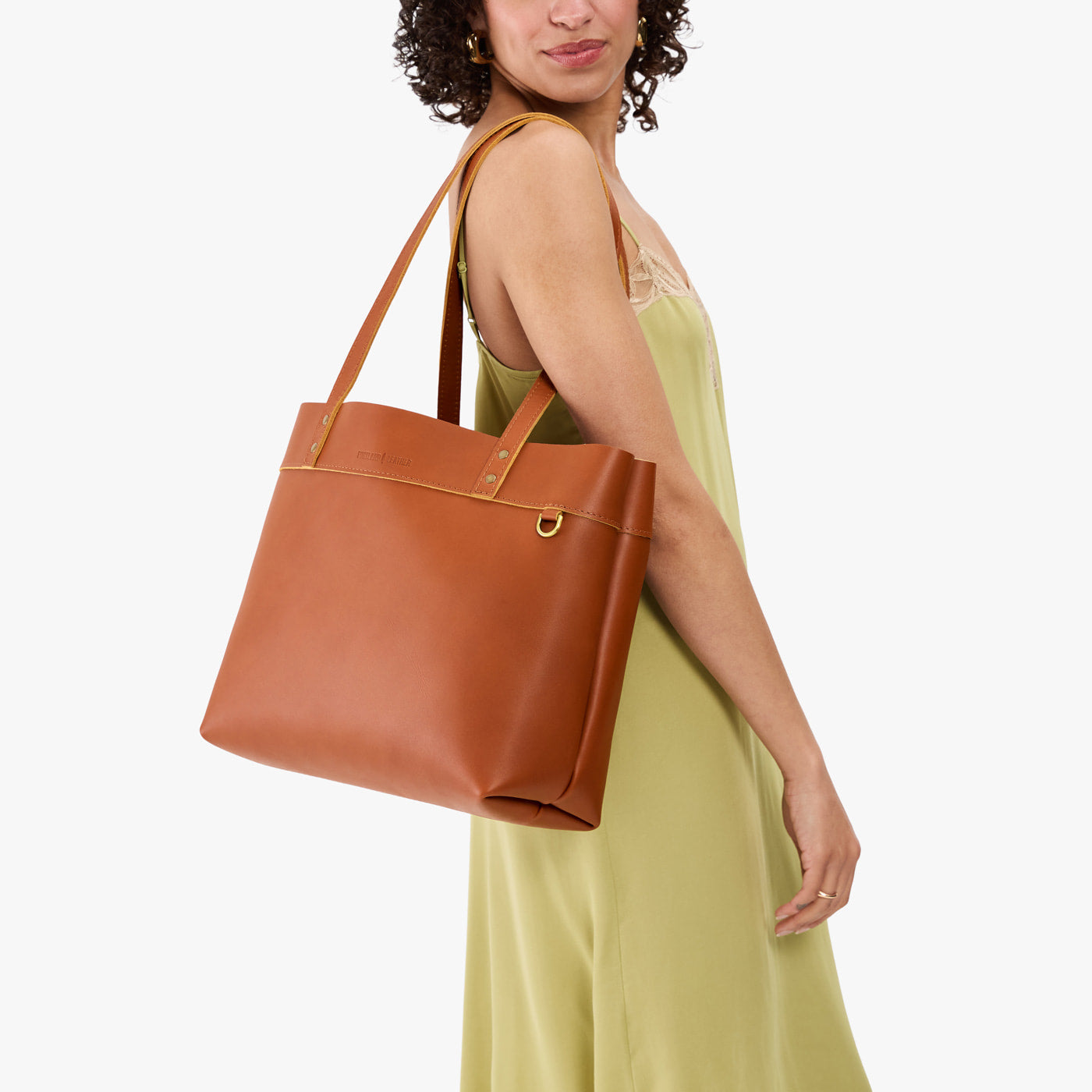 Honey*Large*Classic | Model wearing leather tote bag with riveted straps and exterior key loop