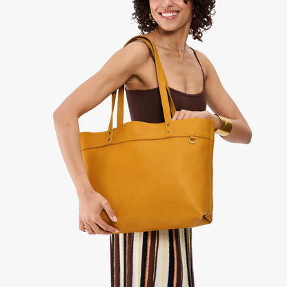 Sunshine*Large*Classic | Model wearing leather tote bag with riveted straps and exterior key loop