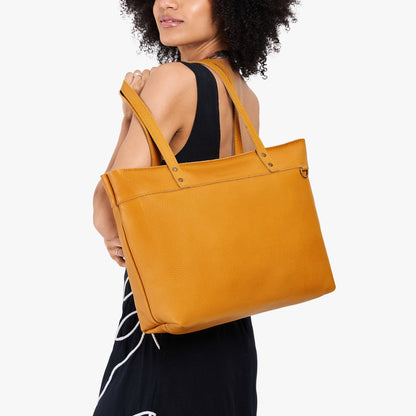 Sunshine*Large*Zipper | Model wearing leather tote bag with riveted straps and exterior key loop