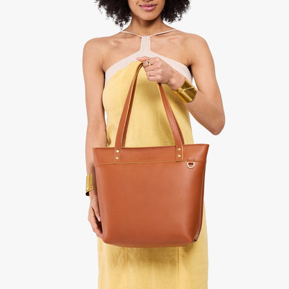 Honey*Medium*Zipper | Model wearing leather tote bag with riveted straps and exterior key loop