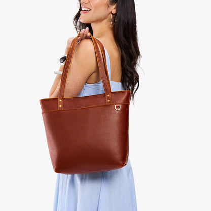 Nutmeg*Medium*Zipper | Model wearing leather tote bag with riveted straps and exterior key loop