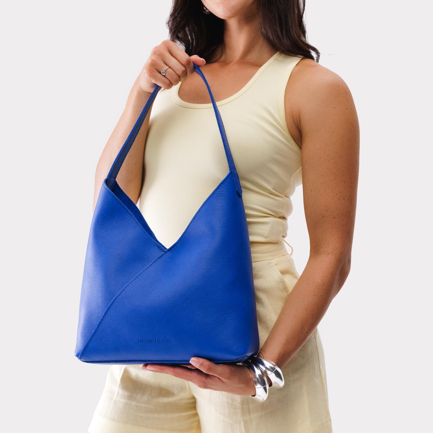 Astro Blue*Large | Model wearing mid-size shoulder bag with magnetic snap closure