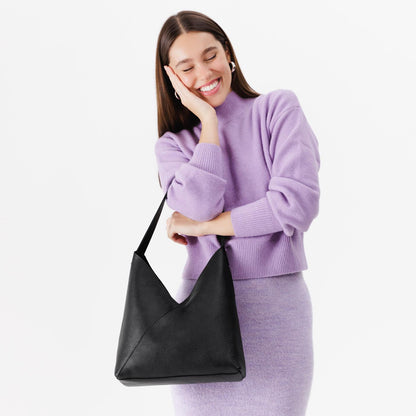 Pebbled--black*Large | Model wearing mid-size shoulder bag with magnetic snap closure