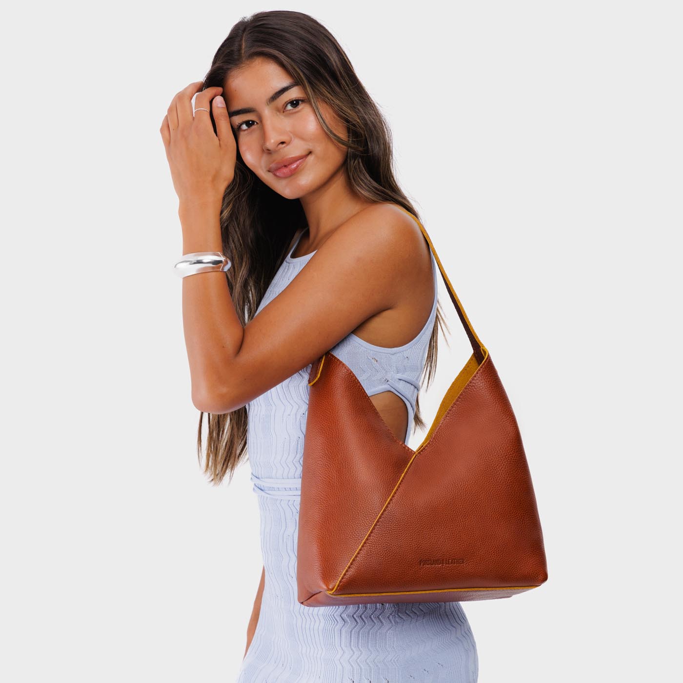 Sienna*Large | Model wearing mid-size shoulder bag with adjustable strap and magnetic snap closure