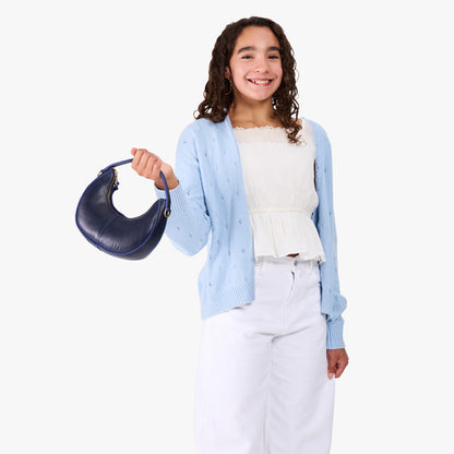 Cobalt | Model with a crescent shaped shoulder bag with zipper closure and gold accents