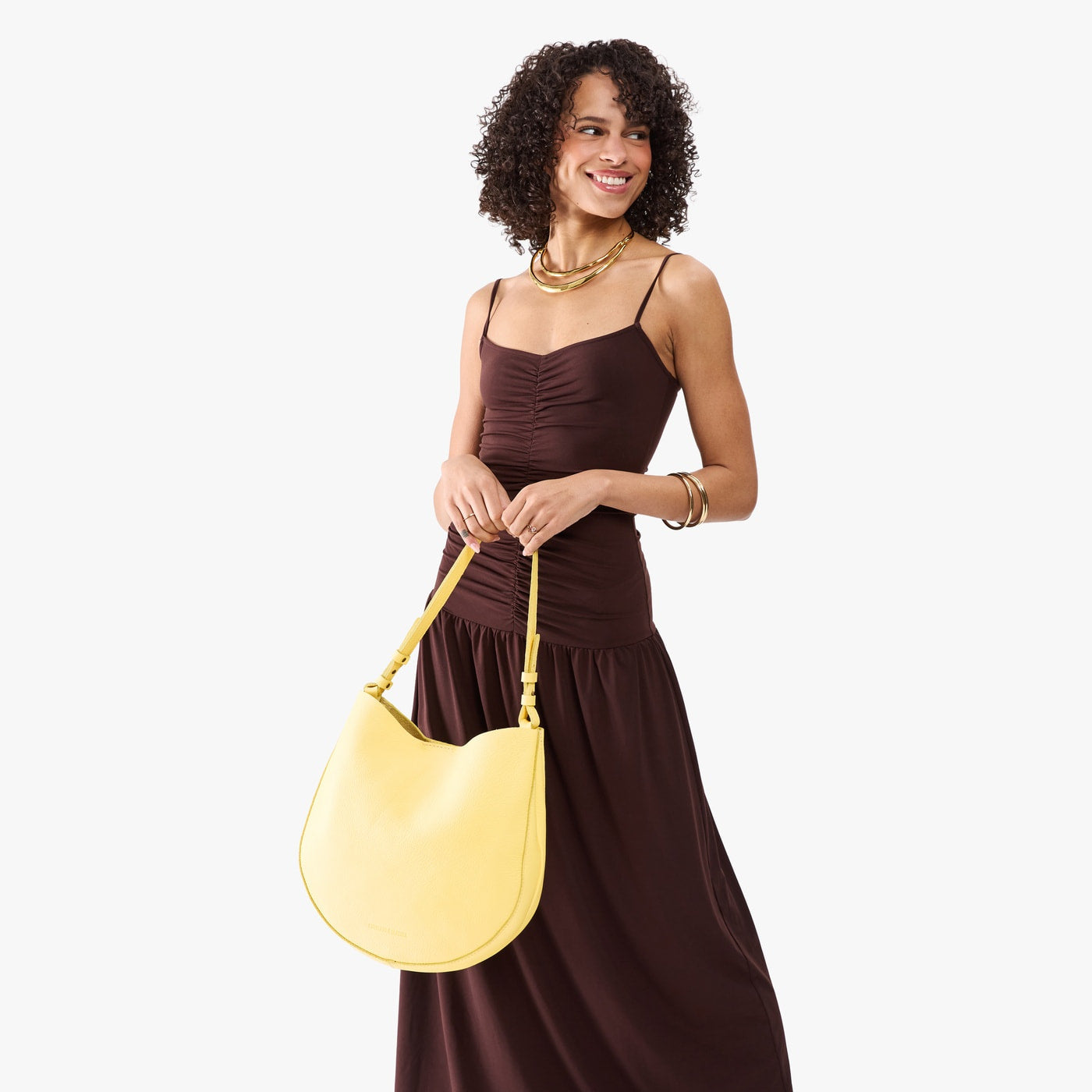 Butter Bliss*Large | Model holding round leather purse with adjustable shoulder strap