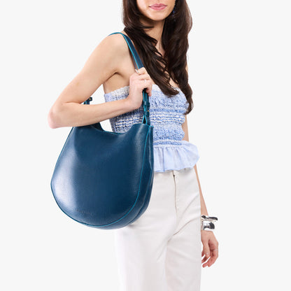 Caspian*Large | Model holding round leather purse with adjustable shoulder strap