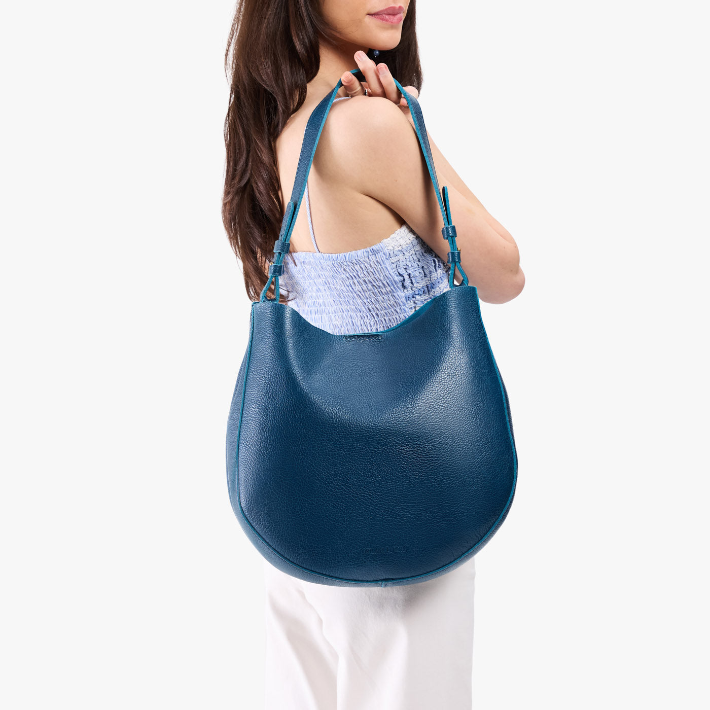 Caspian*Large | Model holding round leather purse with adjustable shoulder strap