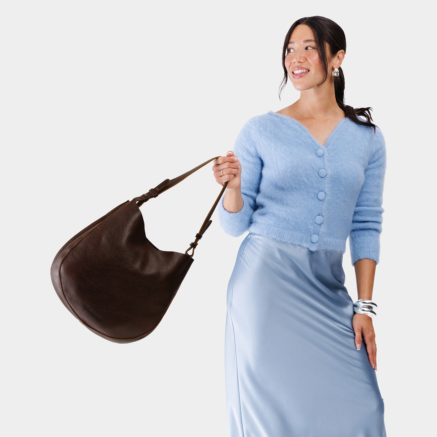 Coldbrew*Large | Woman wearing rounded shoulder bag with adjustable strap on a white background