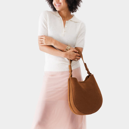 Jackson*Large | Woman wearing rounded shoulder bag with adjustable strap on a white background