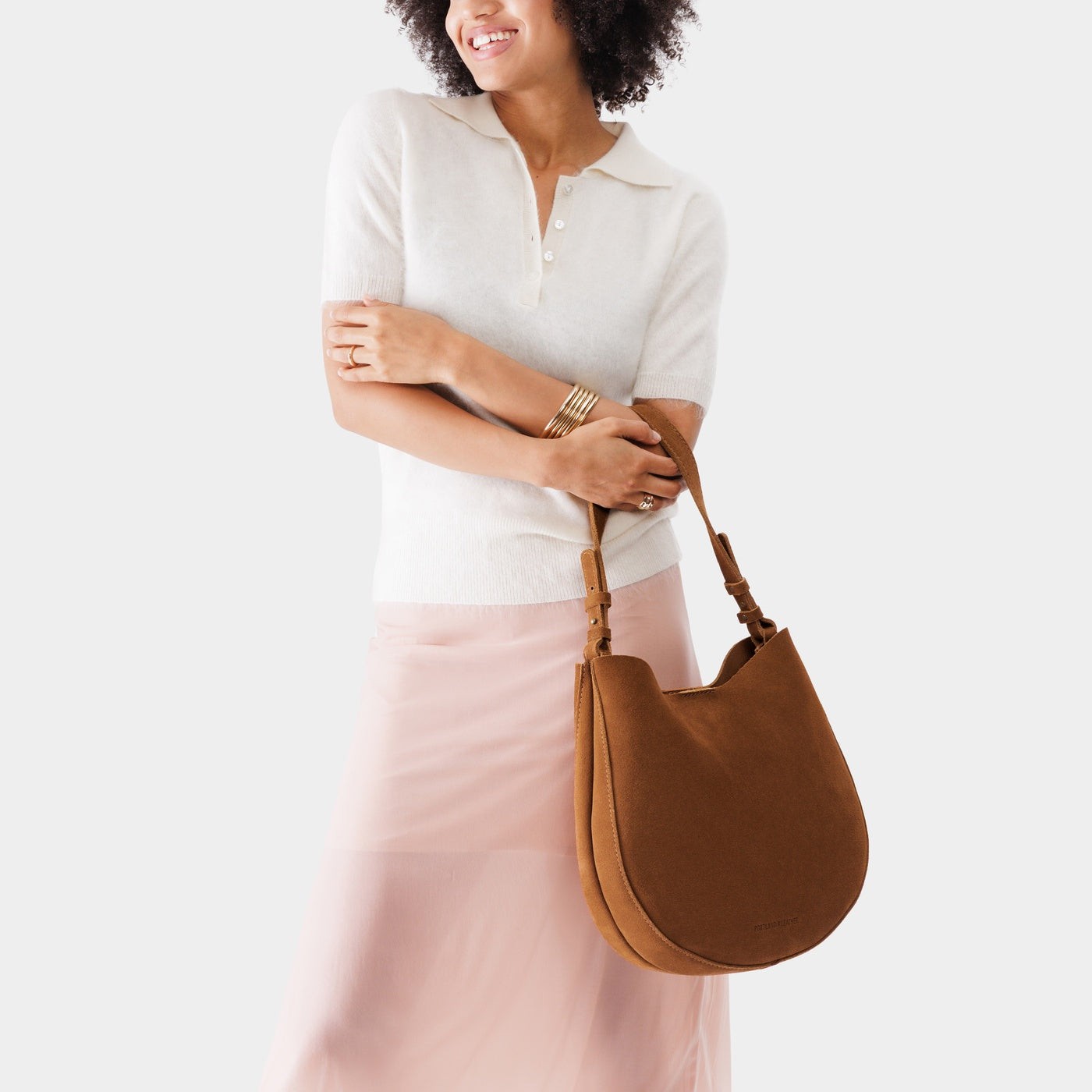 Jackson*Large | Woman wearing rounded shoulder bag with adjustable strap on a white background