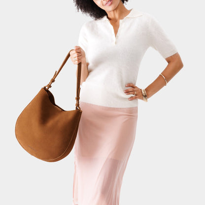 Jackson*Large | Woman wearing rounded shoulder bag with adjustable strap on a white background