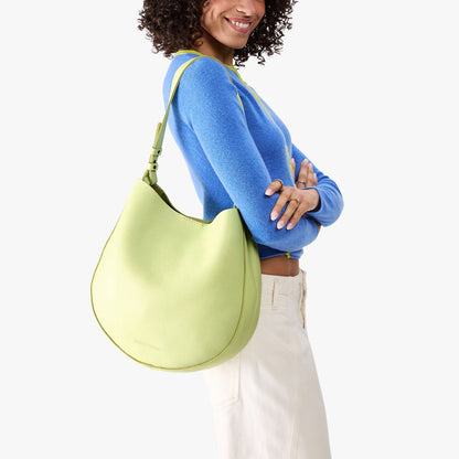 Shadow Lime*Large | Model carrying round leather purse with adjustable shoulder strap