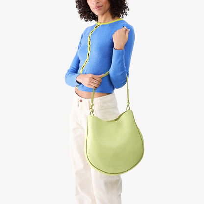 Shadow Lime*Large | Model carrying round leather purse with adjustable shoulder strap