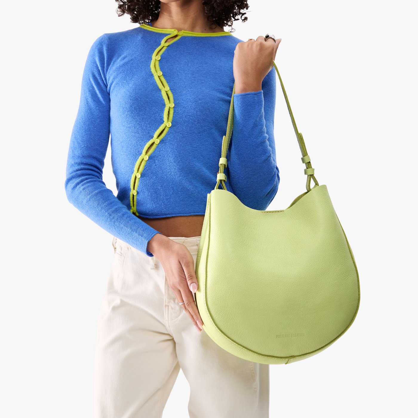 Shadow Lime*Large | Model holding round leather purse with adjustable shoulder strap