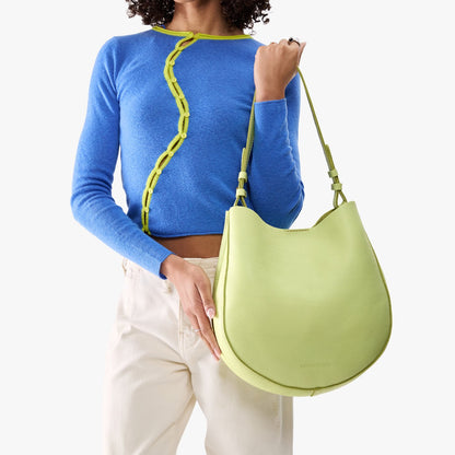 Shadow Lime*Large | Model holding round leather purse with adjustable shoulder strap