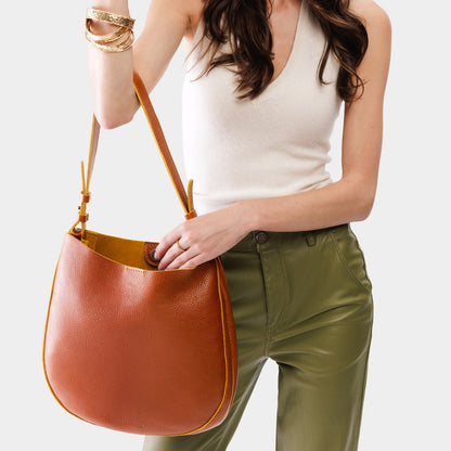 Sienna*Large | Woman wearing rounded shoulder bag with adjustable strap on a white background