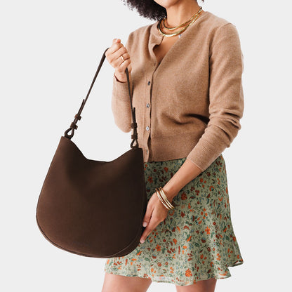 Stagecoach*Large | Woman wearing rounded shoulder bag with adjustable strap on a white background