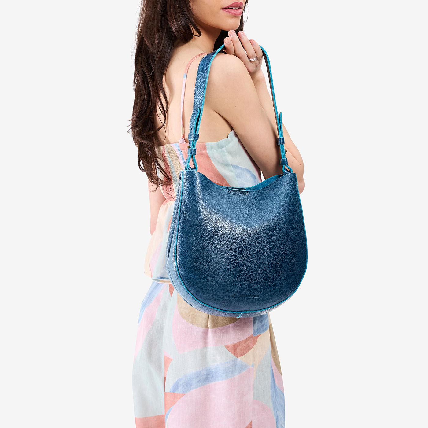 Caspian*Medium | Model holding round leather purse with adjustable shoulder strap